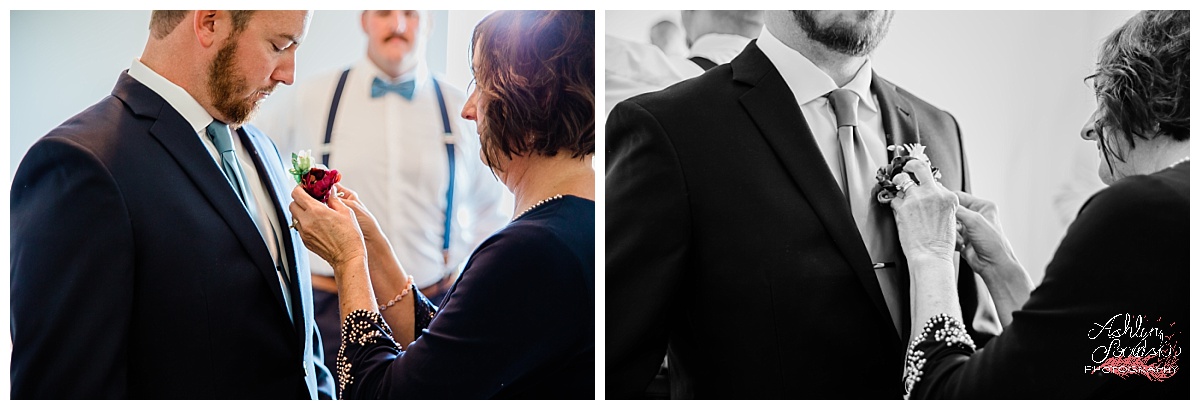 groom getting ready with his mom helping him put his boutonniere on his suit coat 