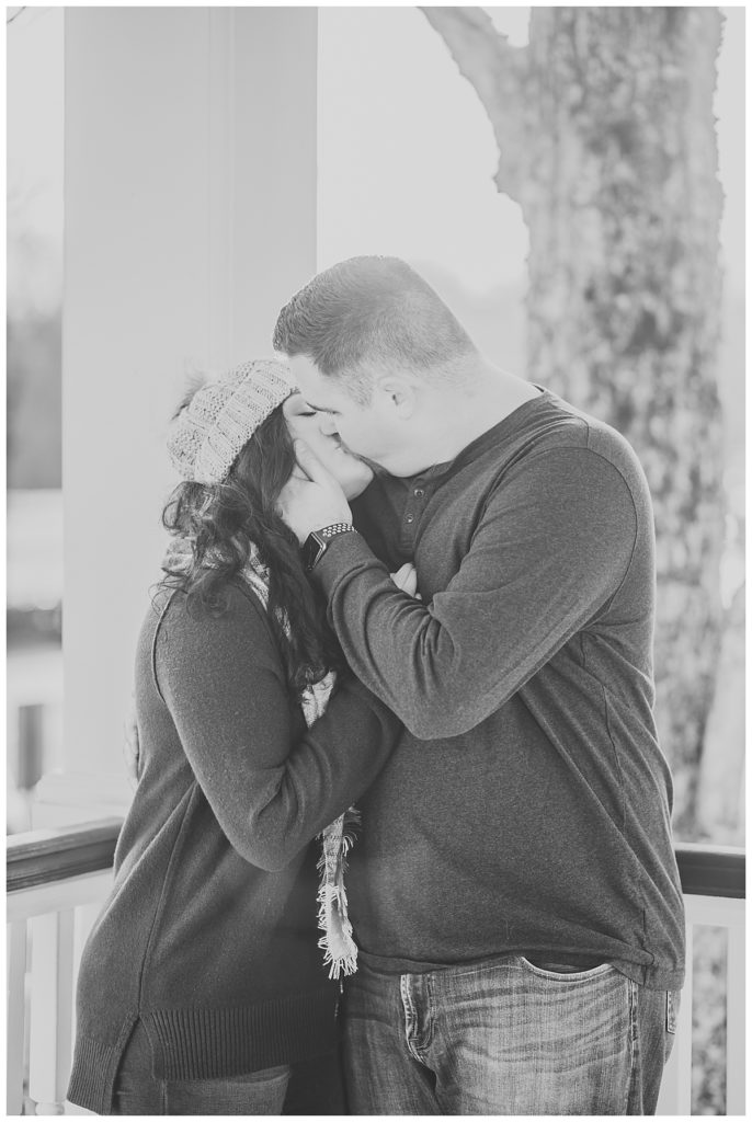 Black and white photo of newly engaged couple kissing