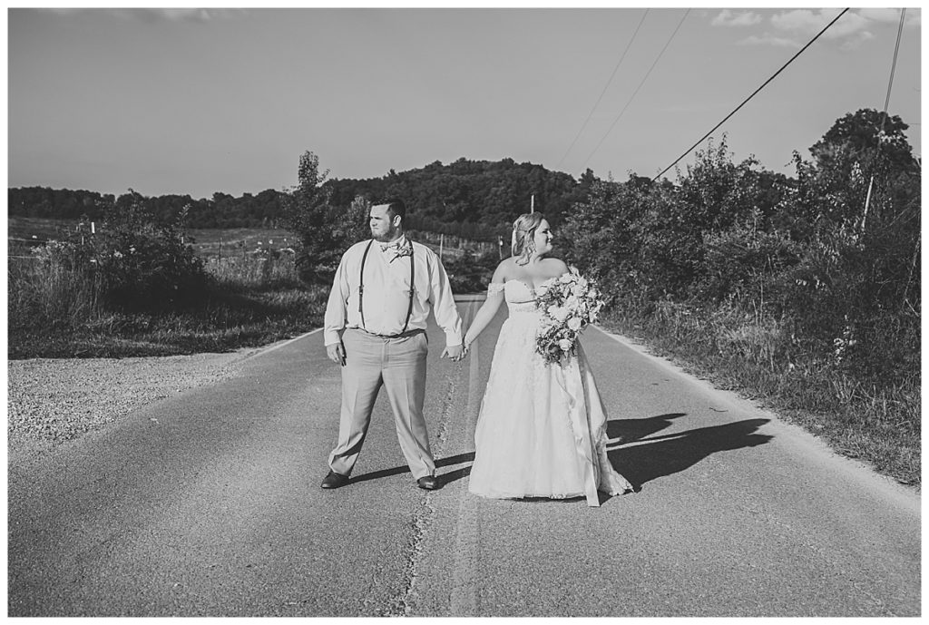 bride and groom standing in the middle of the road at cruze farms