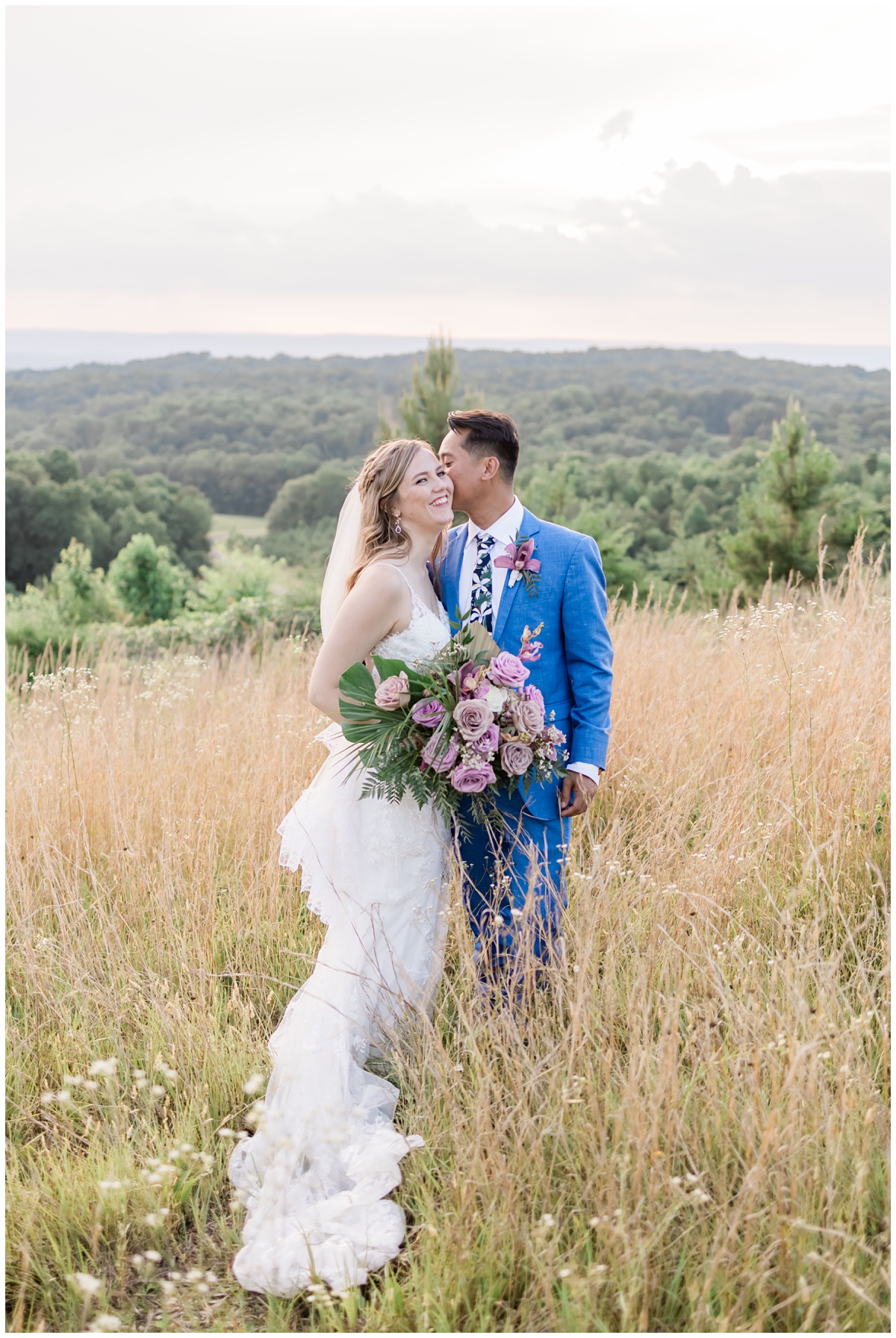 bride and groom in field kissing and celebrating their recent marriage