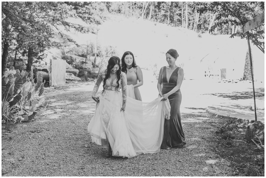 bridesmaids helping bride walk with dress