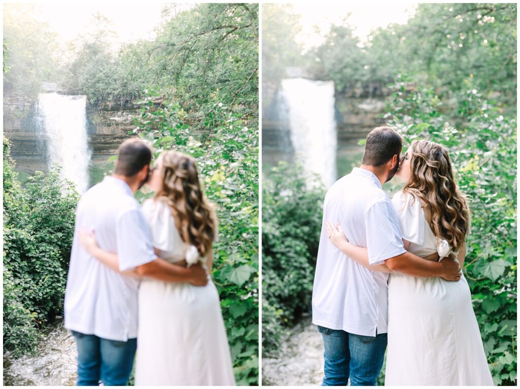 couple standing in front of minnehaha falls watching the waterfall