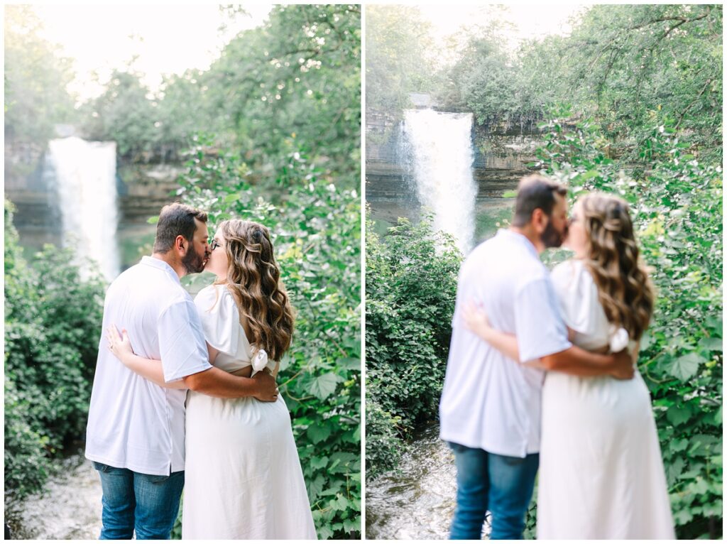couple standing in front of minnehaha falls watching the waterfall