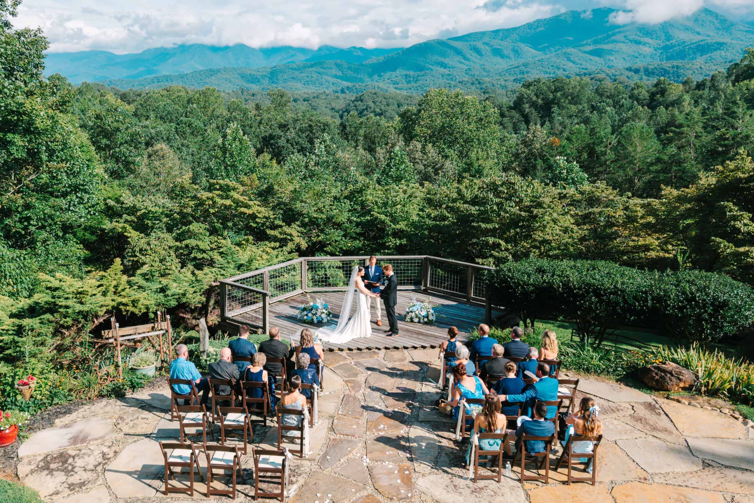 Scenic outdoor wedding with mountain views and natural greenery backdrop.