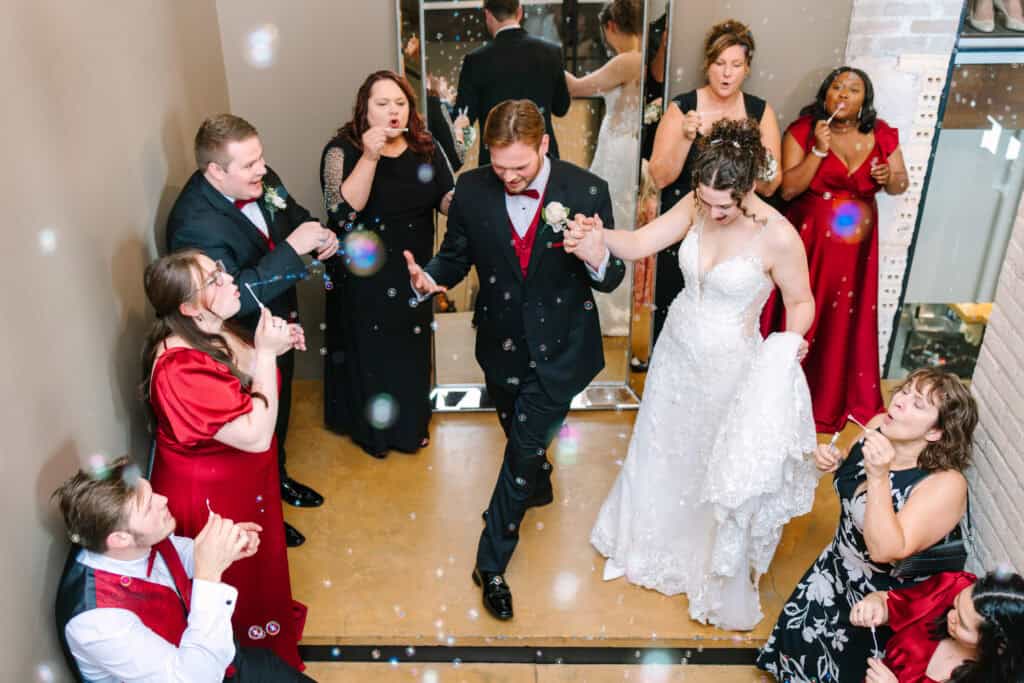 Olivia + Andrew Wedding Newlyweds entering their reception as guests cheer and toss confetti
