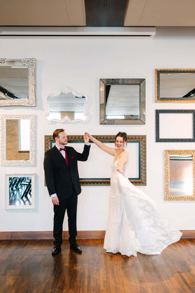 Olivia + Andrew Wedding Bride and groom holding hands as her dress moves during a twirl