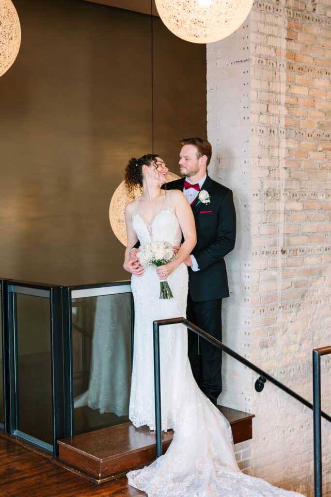 Olivia + Andrew Wedding Bride and groom embracing on a staircase inside FIVE Event Center