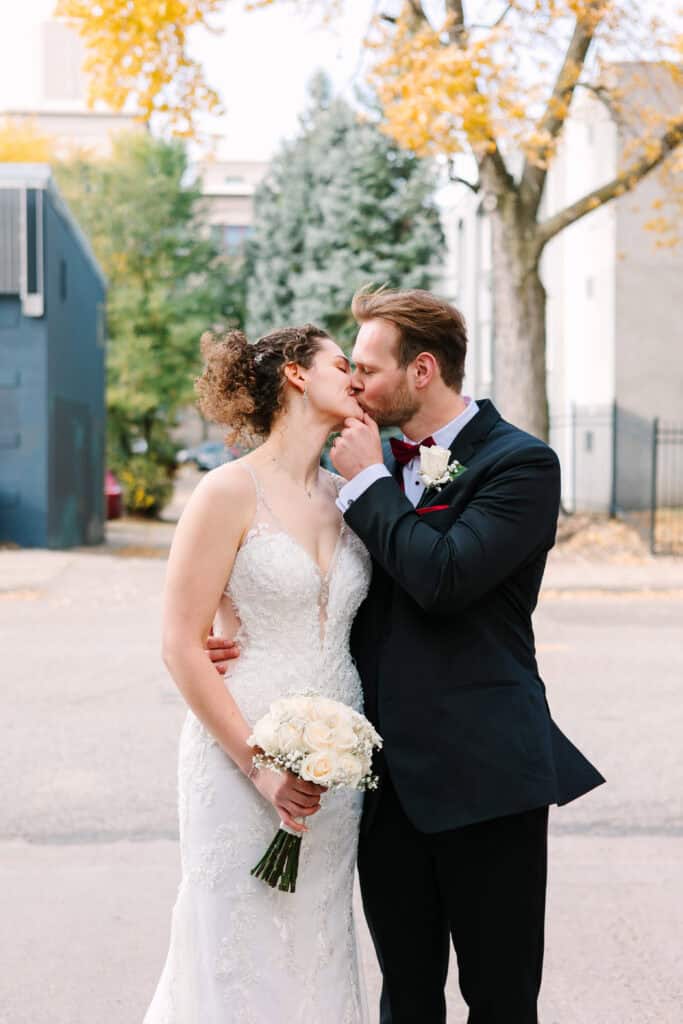 Olivia + Andrew Wedding Bride and groom kissing during outdoor fall wedding portraits