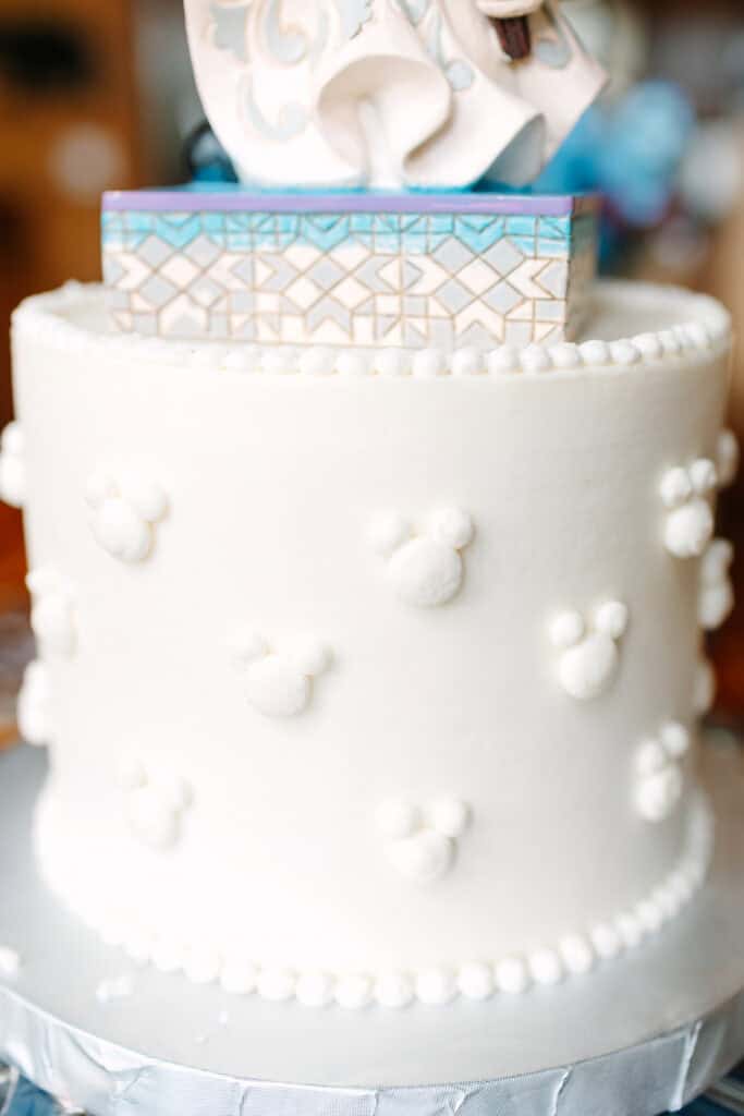 Close-up of a white wedding cake decorated with pearl accents and delicate sugar flowers