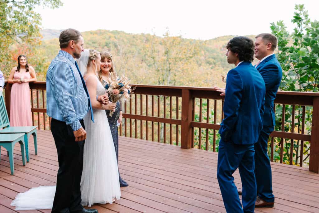 Bride arriving at the deck ceremony as the groom waits beside the officiant