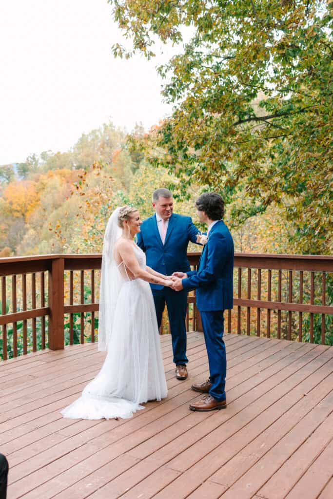 Bride and groom exchanging vows with their officiant on the cabin deck