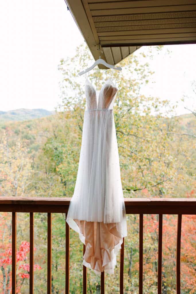 White wedding dress hanging from a cabin deck overlooking the Smoky Mountains