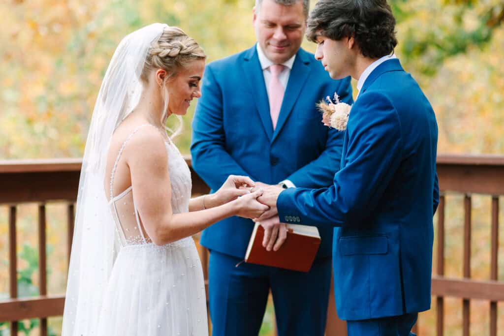 Groom placing a wedding ring on the bride's finger during the ceremony
