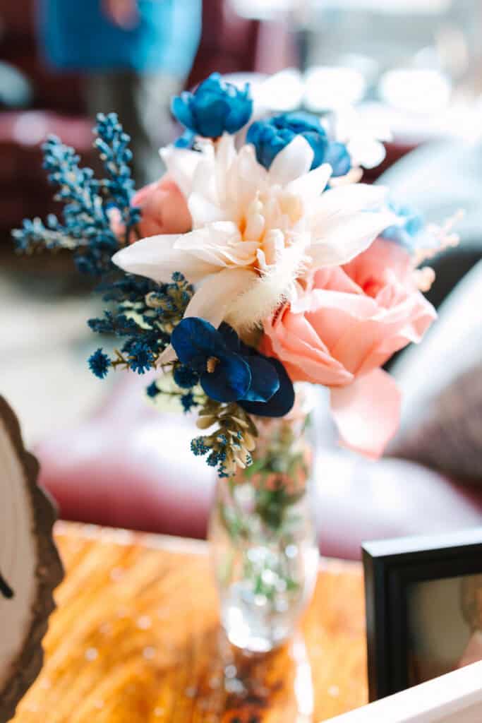 Colorful bridal bouquet with pink, peach, white, and blue flowers