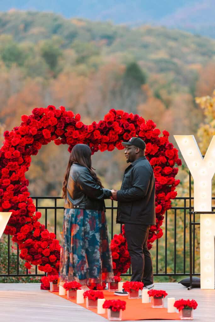 Bobby + Alyssa Proposal Couple standing together inside a red rose heart before a Smoky Mountain proposal