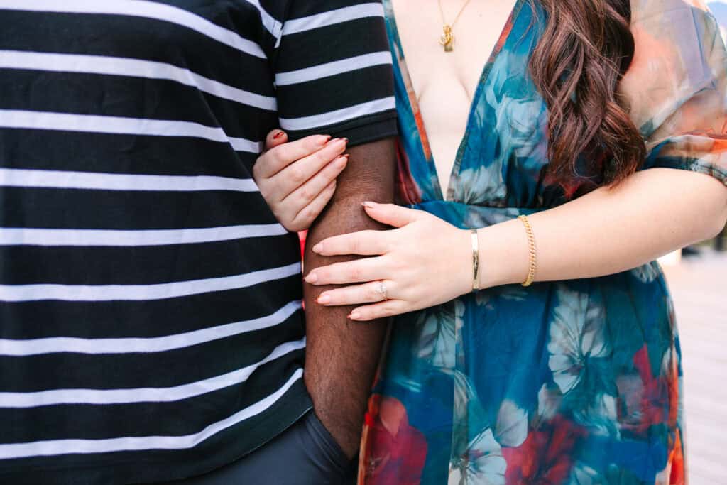 Bobby + Alyssa Proposal Close view of a newly engaged couple holding hands and showing the ring