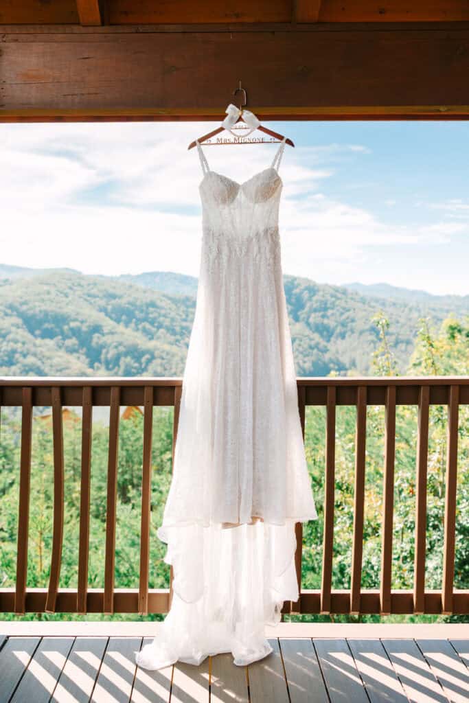 Lauren + Connor Wedding Wedding dress hangs on balcony doors overlooking the Smoky Mountain ridges