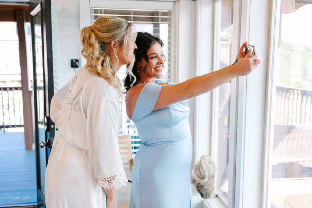 Lauren + Connor Wedding Bride and bridesmaid take a selfie beside the getting-ready windows