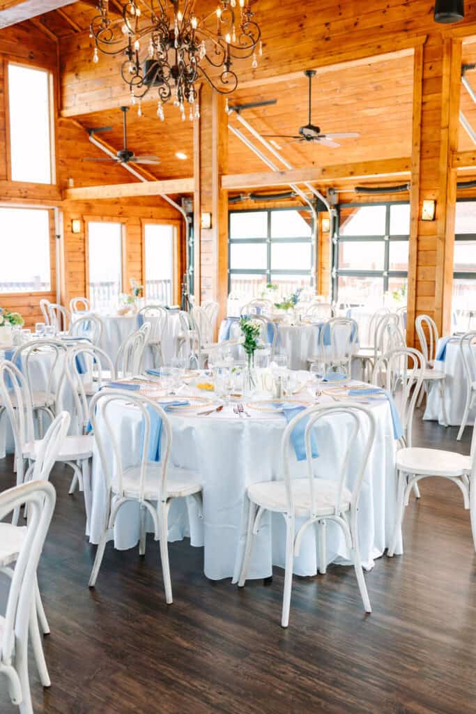 Lauren + Connor Wedding Reception tables inside The Magnolia Venue's wood and window reception room