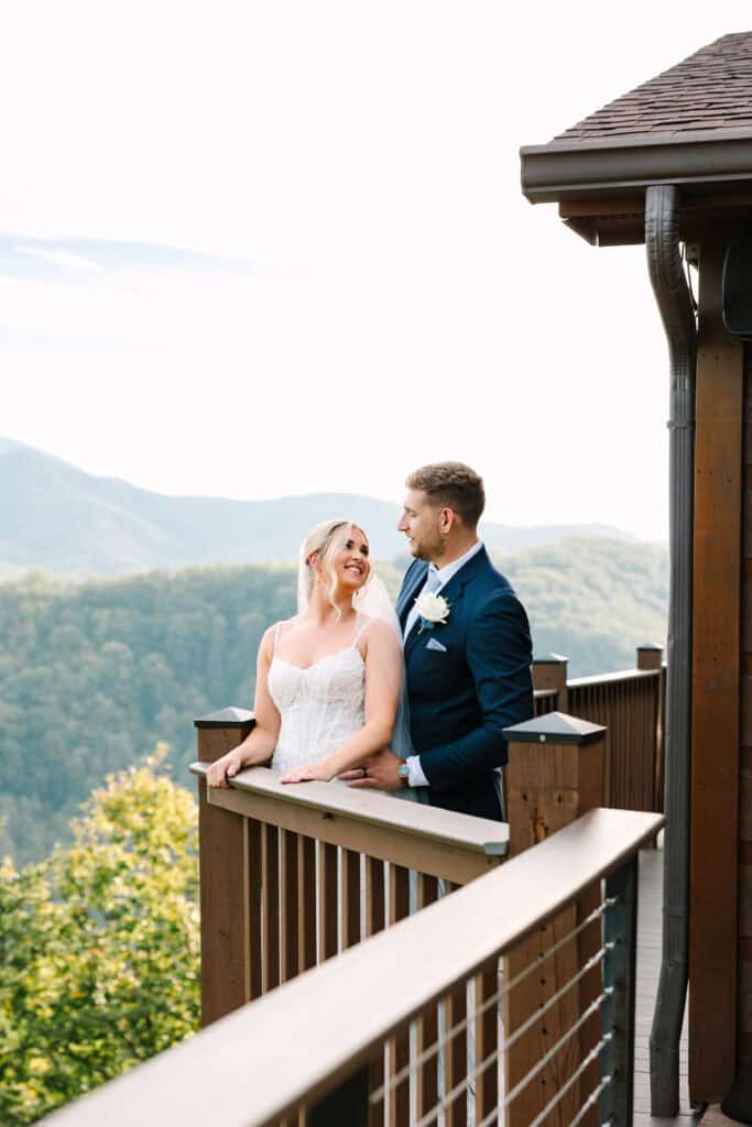 Lauren + Connor Wedding Bride and groom embrace beside a wooden balcony post