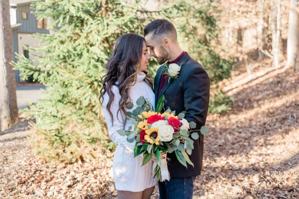 Laura + Steve Elopement Groom kissing the bride as she holds her red and yellow bouquet