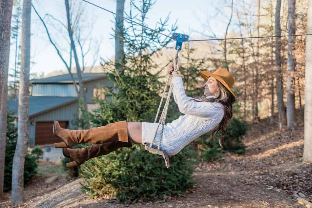 Laura + Steve Elopement Bride swinging on a rope swing among the trees