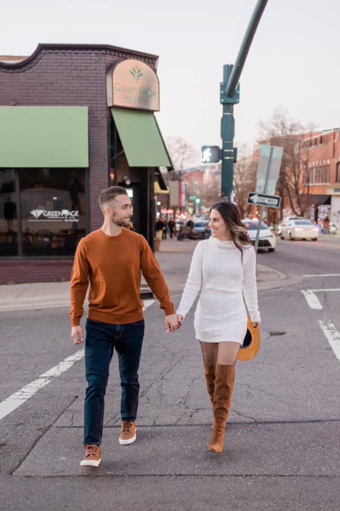 Laura + Steve Elopement Couple walking hand in hand across a downtown Asheville street