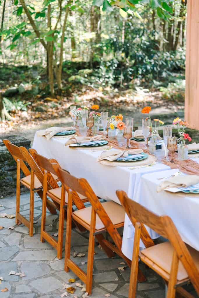 Thaís + Nick Wedding Reception tables with wooden chairs under the trees