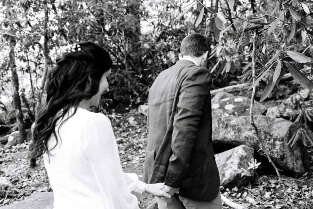 Thaís + Nick Wedding Black and white photo of the bride looking back at the groom