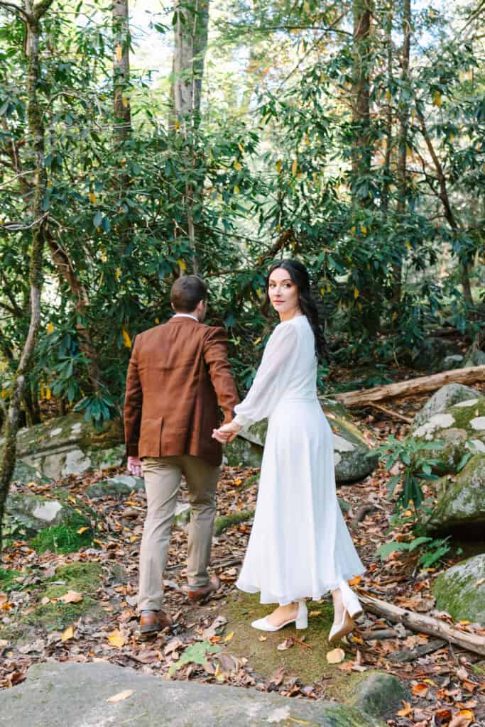 Thaís + Nick Wedding Bride leading the groom by the hand through the Elkmont forest