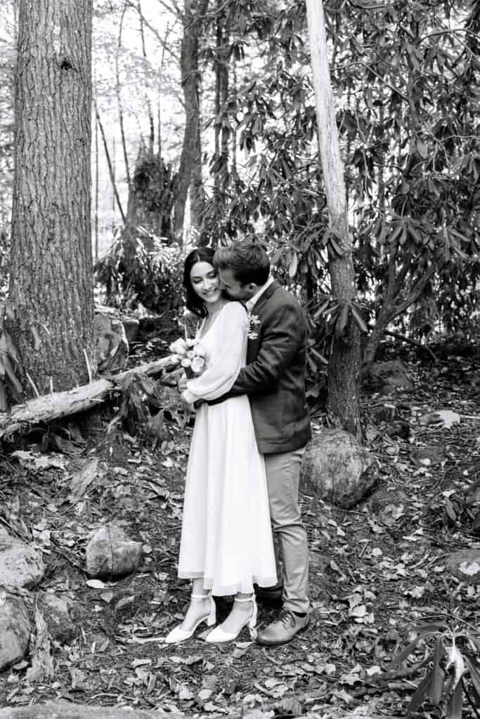 Thaís + Nick Wedding Black and white photo of the couple embracing among tall trees