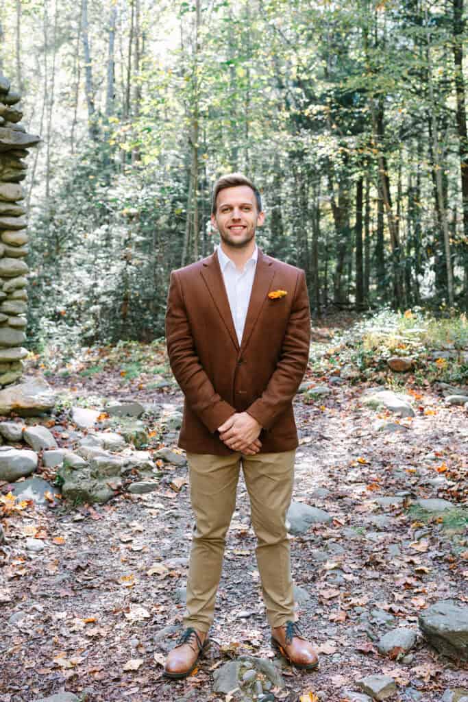 Thaís + Nick Wedding Groom portrait in a rust suit jacket in the forest