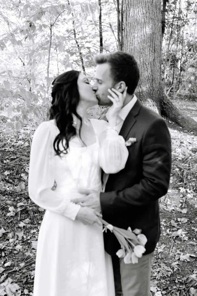 Thaís + Nick Wedding Black and white photo of the groom kissing the bride on the cheek