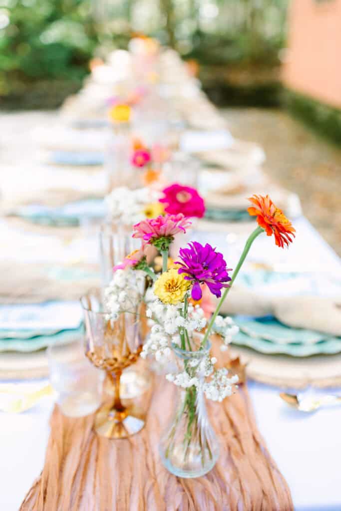 Thaís + Nick Wedding Bright pink and orange flowers in bud vases on the reception table