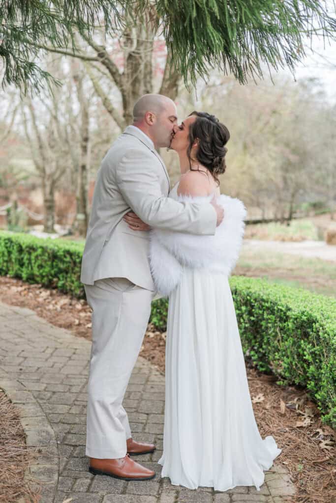 Sarah + Jake Wedding Groom kissing the bride on the garden path