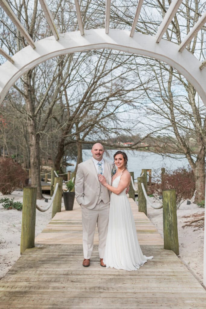 Sarah + Jake Wedding Couple under the white arbor on the dock