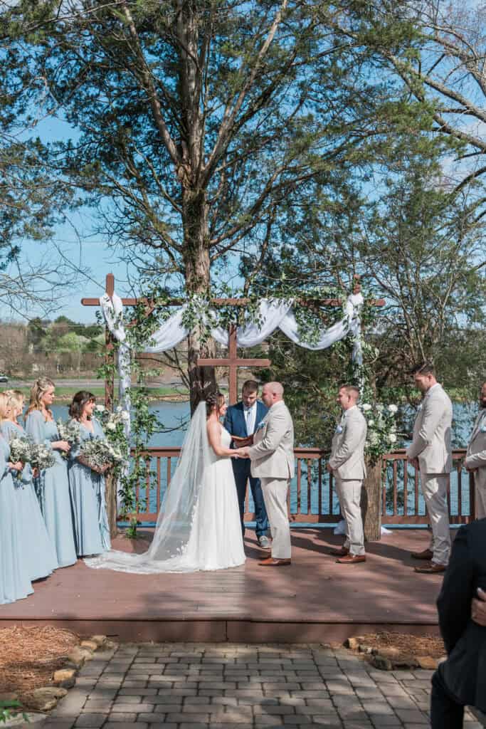 Sarah + Jake Wedding Wedding party standing by the water during the vows