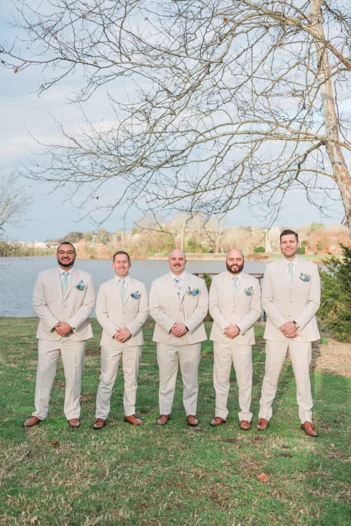 Sarah + Jake Wedding Groom and groomsmen in tan suits by the lake at The Pavilion at Hunter Valley Farm